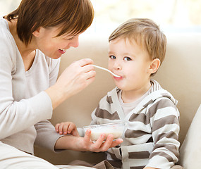 Image showing Cute little boy is fed using spoon