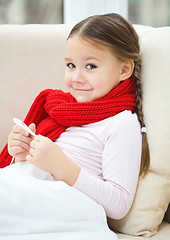 Image showing Ill little girl is reading thermometer