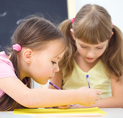 Image showing Little girls are writing using a pen