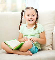 Image showing Little girl reads a book