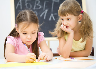 Image showing Little girls are writing using a pen