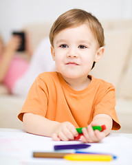 Image showing Little boy is drawing on white paper