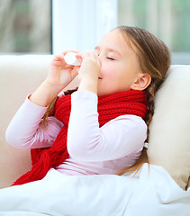 Image showing Little girl spraying her nose