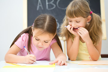 Image showing Little girls are writing using a pen