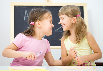 Image showing Little girls are writing using a pen