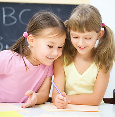 Image showing Little girls are writing using a pen