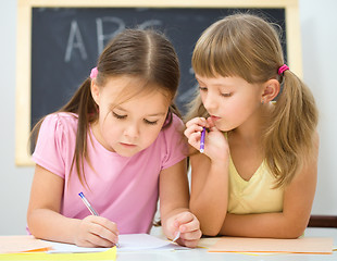 Image showing Little girls are writing using a pen