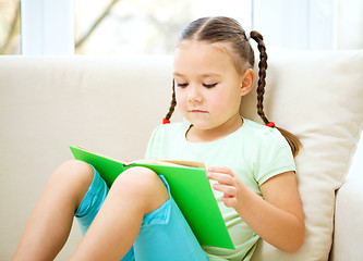 Image showing Little girl reads a book