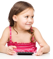 Image showing Little girl is using calculator