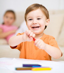 Image showing Little boy is drawing on white paper