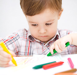 Image showing Little boy is drawing on white paper