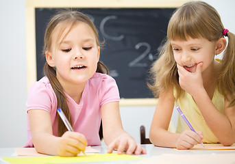 Image showing Little girls are writing using a pen