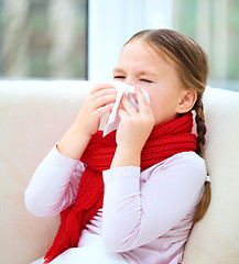 Image showing Little girl is blowing her nose