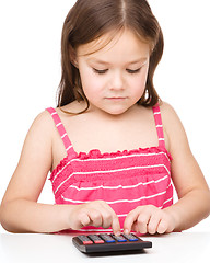Image showing Little girl is using calculator