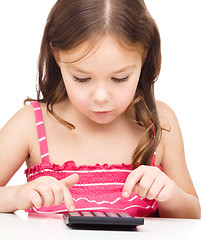 Image showing Little girl is using calculator