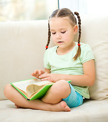 Image showing Little girl reads a book