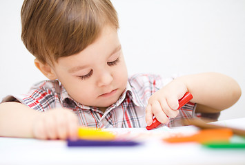 Image showing Little boy is drawing on white paper