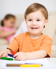 Image showing Little boy is drawing on white paper