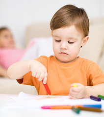 Image showing Little boy is drawing on white paper