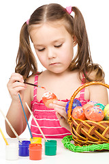 Image showing Little girl is painting eggs preparing for Easter