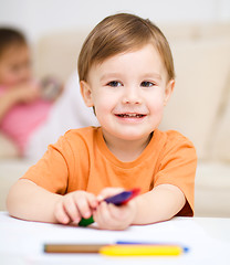 Image showing Little boy is drawing on white paper