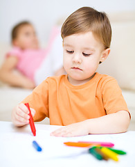 Image showing Little boy is drawing on white paper