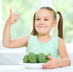 Image showing Cute little girl is eating green grapes