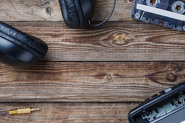 Image showing Cassette tapes, player and headphones over wooden table. top view.