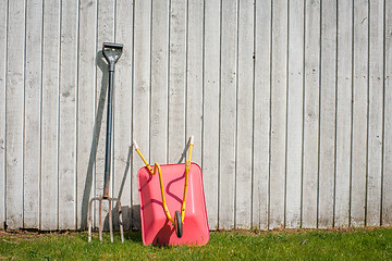 Image showing Pitchfork and a wheelbarrow in a garden