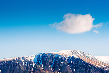 Image showing Fluffy white cloud over a mountain top