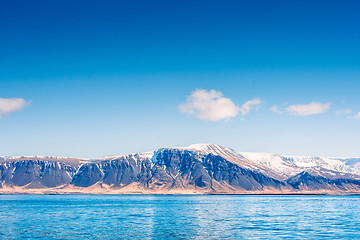 Image showing Skies over a mountain with snow by the sea