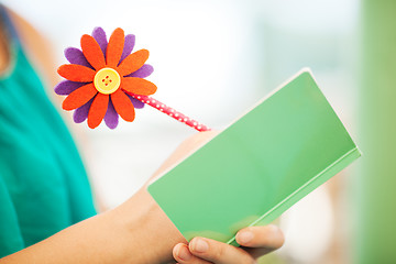 Image showing Woman Writing in Notebook with Flower Pencil