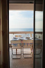 Image showing Dining table set on a balcony overlooking the sea