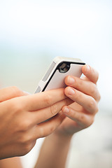 Image showing Child checking a text message on a mobile