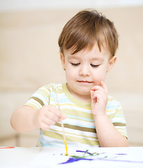 Image showing Little boy is playing with paints