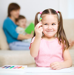 Image showing Little girl is playing with plasticine