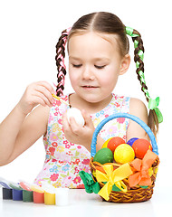 Image showing Little girl is painting eggs preparing for Easter