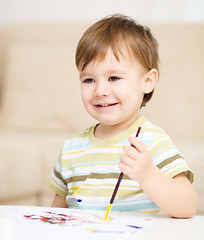 Image showing Little boy is playing with paints