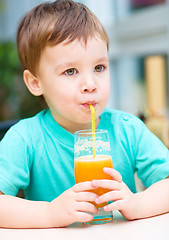 Image showing Little boy with glass of orange juice