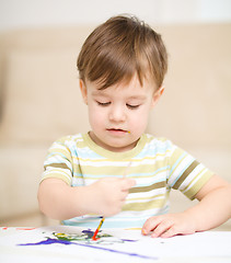 Image showing Little boy is playing with paints