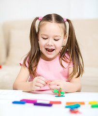 Image showing Little girl is playing with plasticine