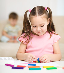 Image showing Little girl is playing with plasticine