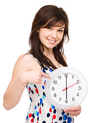 Image showing Young woman is holding big clock