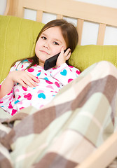 Image showing Cute little girl is talking on a cell phone