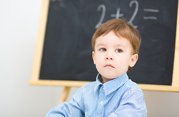 Image showing Little boy is sitting on math lesson