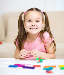 Image showing Little girl is playing with plasticine
