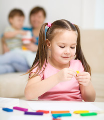 Image showing Little girl is playing with plasticine