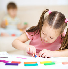 Image showing Little girl is playing with plasticine