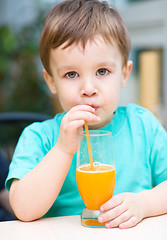 Image showing Little boy with glass of orange juice