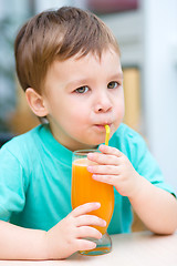 Image showing Little boy with glass of orange juice